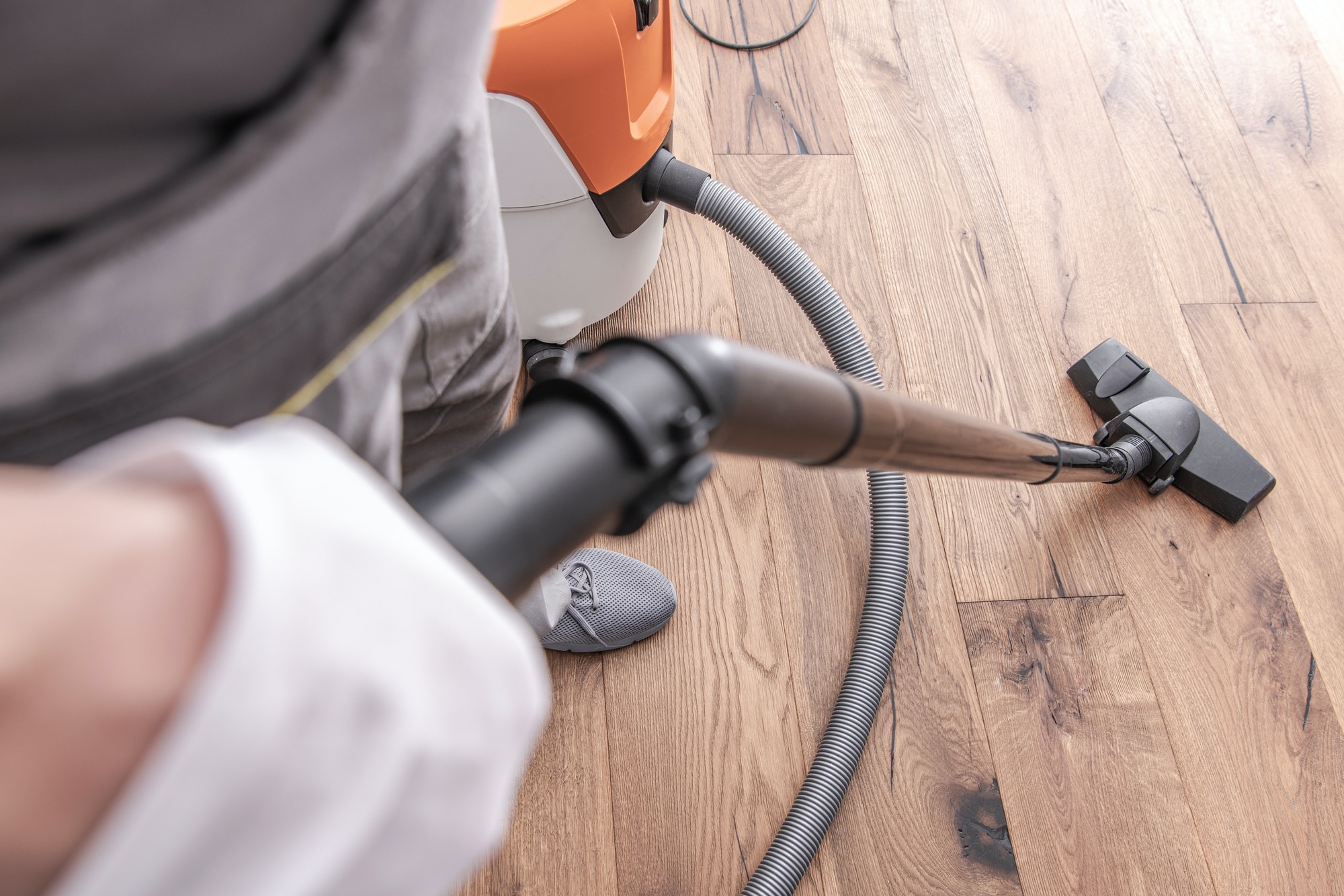 Male Worker Vacuuming Hardwood Flooring